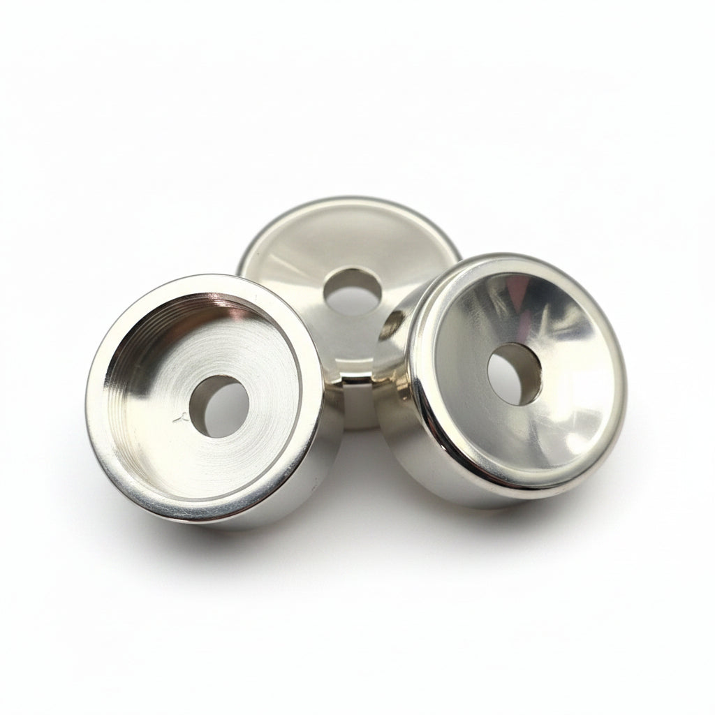 Three small silver metal button tops with clear domes, arranged on a plain light gray background.