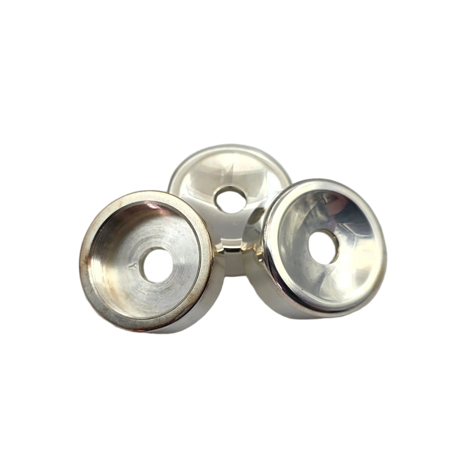 Three small silver metal button tops with clear domes, arranged on a plain light gray background.